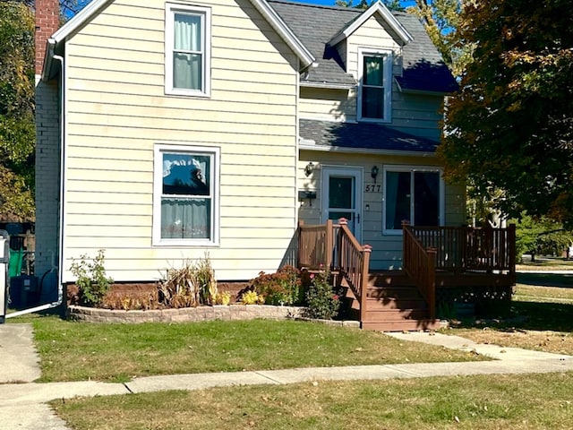 view of front of property featuring a wooden deck and a front lawn