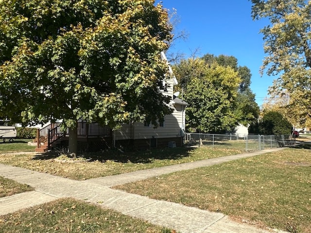 view of side of property featuring a wooden deck and a lawn