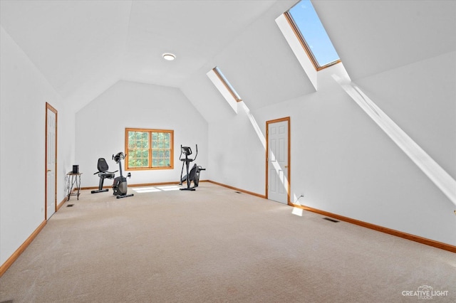 exercise area featuring light carpet and lofted ceiling with skylight