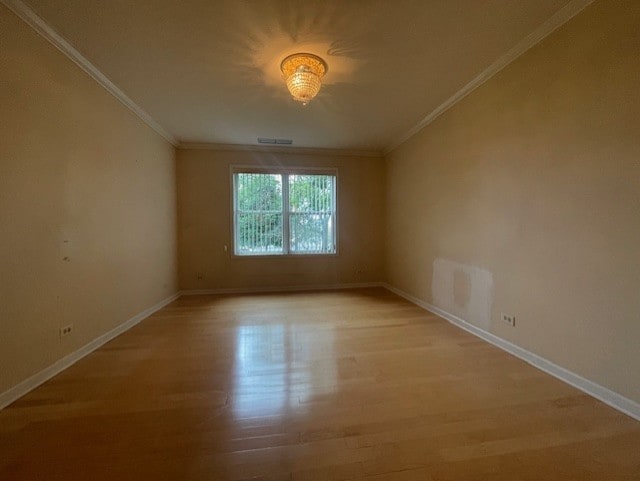 spare room with light hardwood / wood-style floors and crown molding