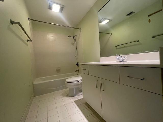 full bathroom featuring tile patterned floors, vanity, toilet, and tiled shower / bath