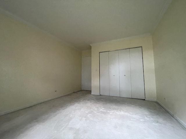 unfurnished bedroom featuring a closet and concrete flooring