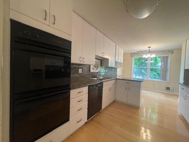 kitchen with kitchen peninsula, light hardwood / wood-style flooring, decorative light fixtures, black appliances, and white cabinets