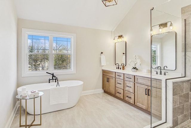 bathroom with double vanity, a soaking tub, a sink, and lofted ceiling