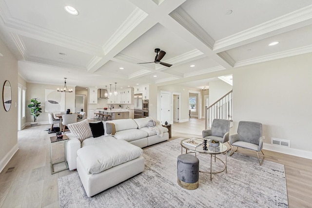 living room featuring light wood-style floors, visible vents, coffered ceiling, and beamed ceiling