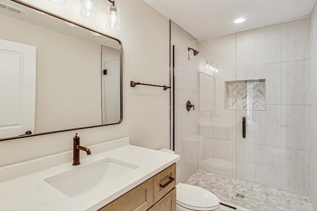 bathroom featuring toilet, a stall shower, vanity, and visible vents