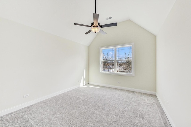 carpeted empty room with vaulted ceiling, a ceiling fan, visible vents, and baseboards