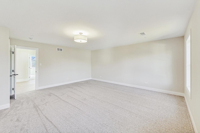 unfurnished room with light carpet, baseboards, and visible vents