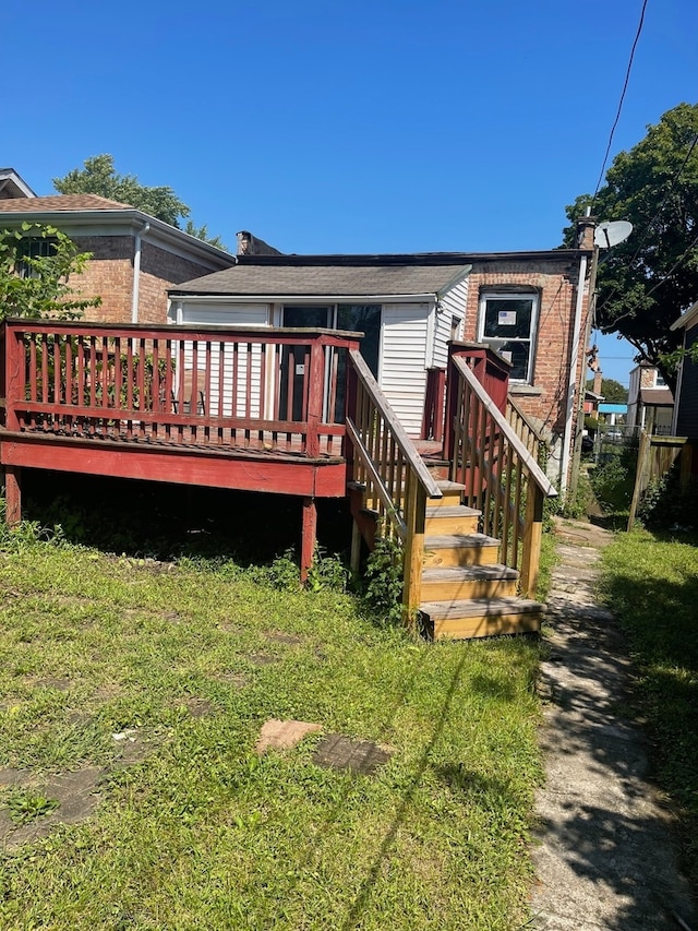 back of house with a deck and a lawn