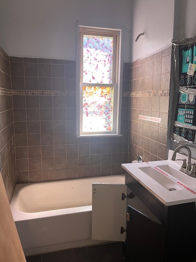 bathroom featuring tile walls, bathtub / shower combination, and vanity