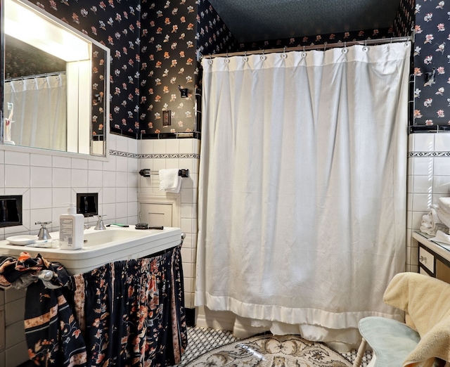 bathroom with tile walls, decorative backsplash, a textured ceiling, and tile patterned floors