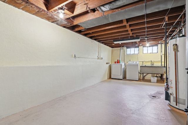 basement with sink, washing machine and clothes dryer, and water heater