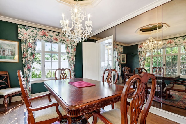 dining room with ornamental molding, hardwood / wood-style flooring, and a notable chandelier