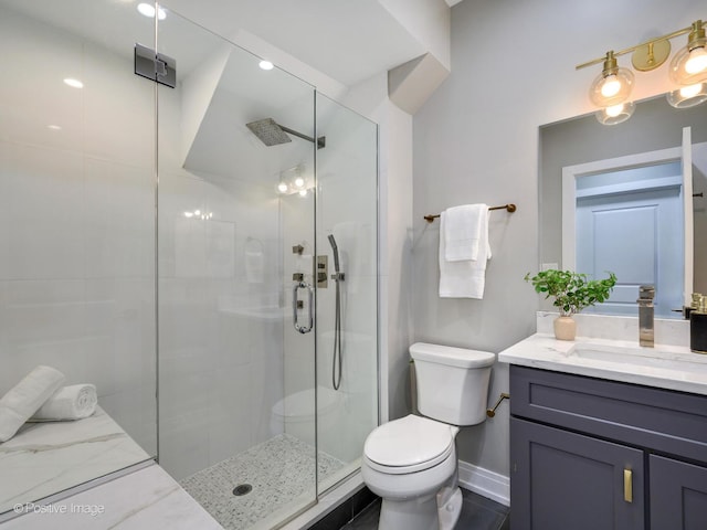 bathroom featuring vanity, toilet, and an enclosed shower