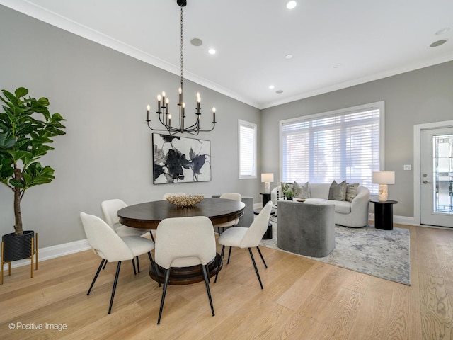 dining space with ornamental molding, a chandelier, and light wood-type flooring