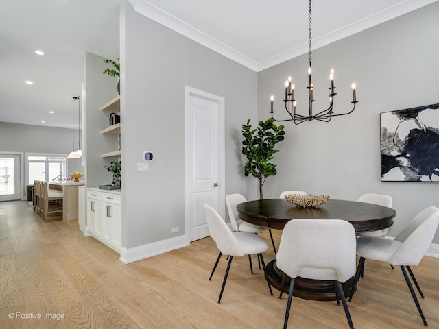 dining room featuring light hardwood / wood-style flooring, ornamental molding, and a chandelier