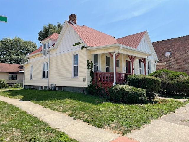 view of home's exterior with a yard and covered porch