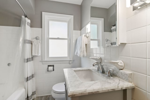 full bathroom with wood-type flooring, vanity, toilet, and tile walls