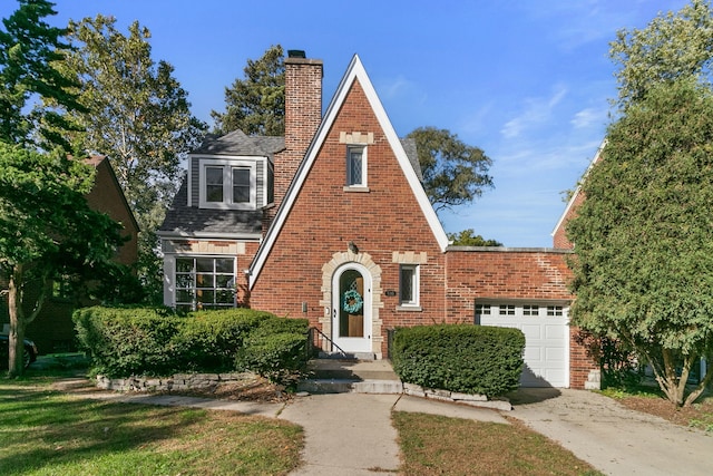 english style home featuring a garage