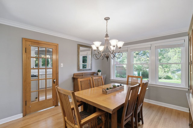 dining area with a notable chandelier, light wood-type flooring, and crown molding