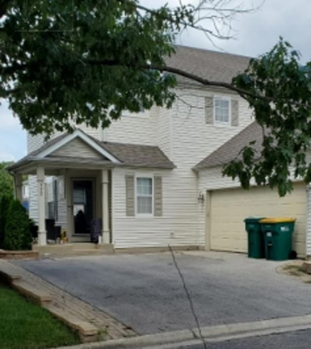 view of front of house featuring a garage, driveway, and a chimney