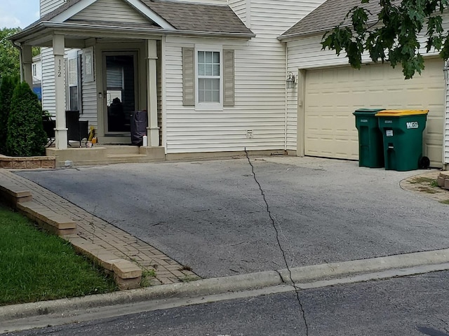 view of front of house with aphalt driveway, roof with shingles, and an attached garage