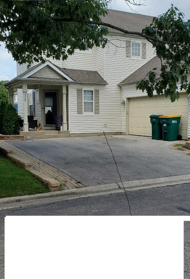 view of front of house featuring roof with shingles, driveway, and an attached garage