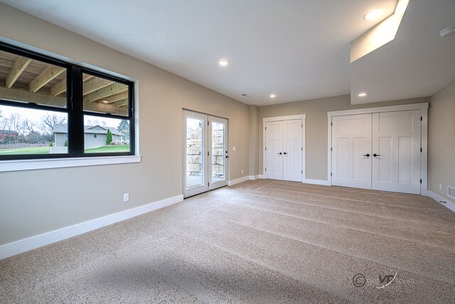 unfurnished bedroom featuring carpet, access to outside, and multiple closets