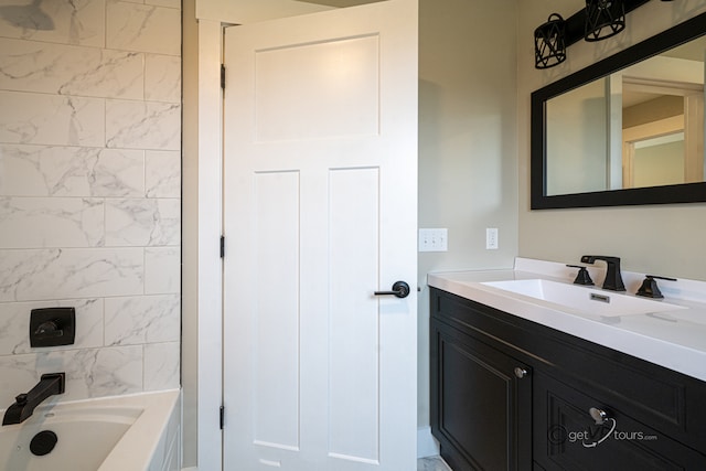 bathroom featuring vanity and tiled shower / bath