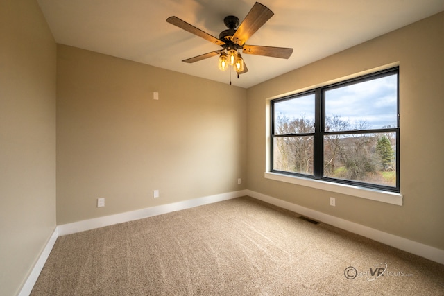 carpeted spare room with ceiling fan