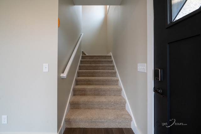 stairs featuring hardwood / wood-style floors