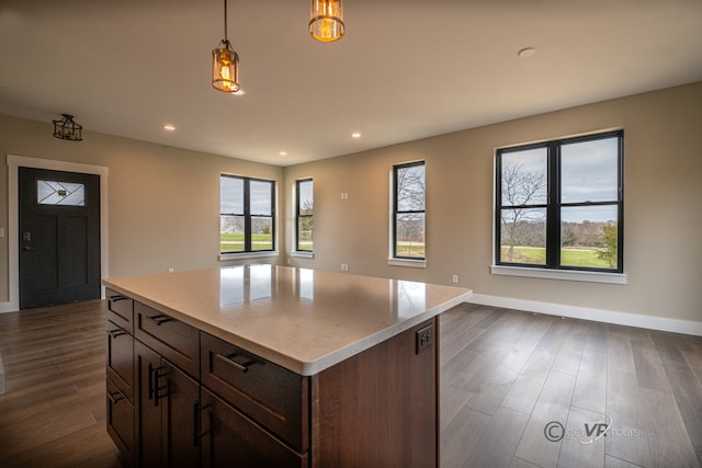 kitchen featuring hanging light fixtures, a kitchen island, and dark wood-type flooring