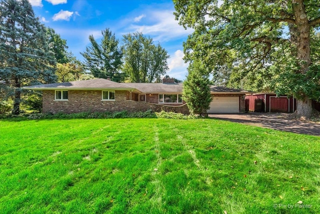 view of front facade with a front yard, brick siding, driveway, and an attached garage