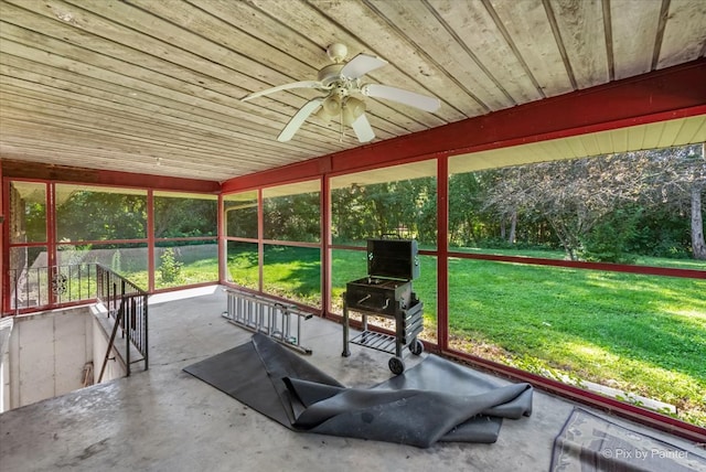 unfurnished sunroom featuring ceiling fan and wooden ceiling