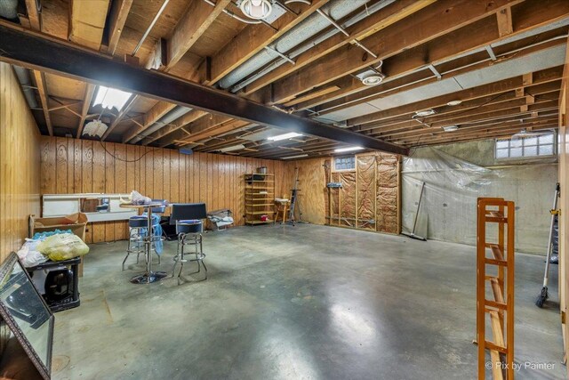 basement featuring wood walls