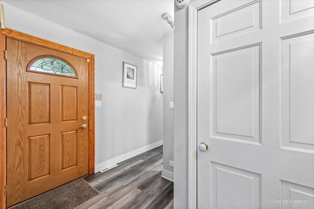 foyer with baseboards and dark wood-type flooring