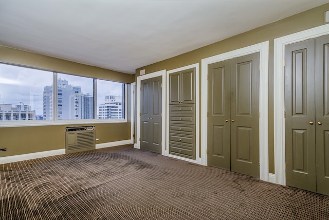 unfurnished bedroom with dark carpet and multiple closets