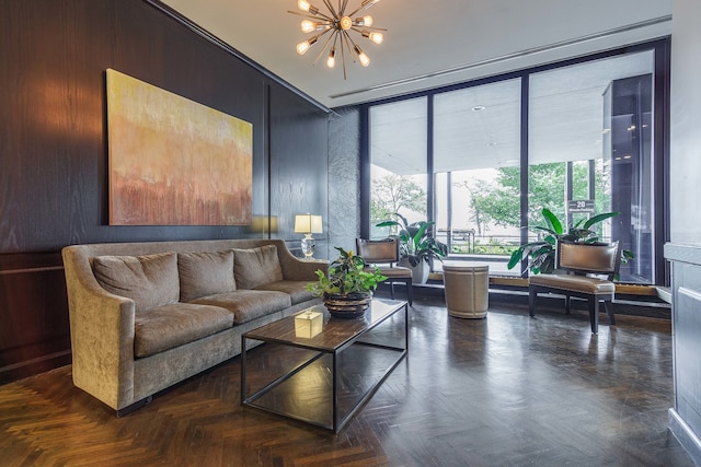 interior space featuring an inviting chandelier, wooden walls, and dark parquet flooring