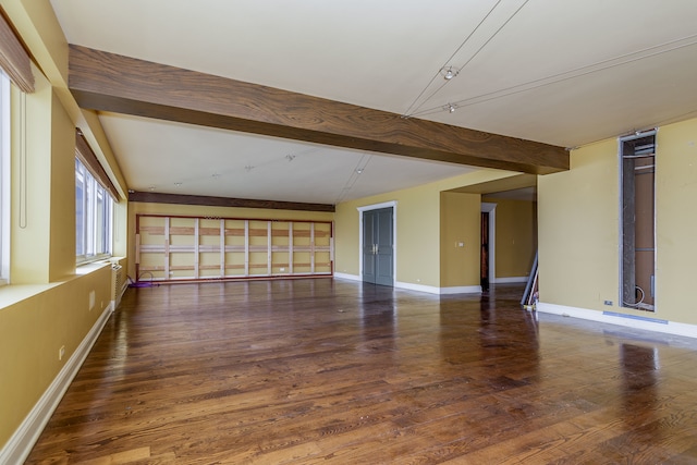 empty room featuring vaulted ceiling with beams and dark wood-type flooring