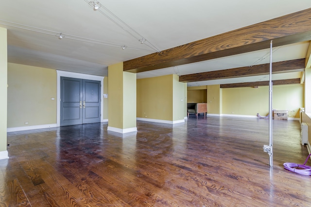 interior space with dark hardwood / wood-style floors and beam ceiling