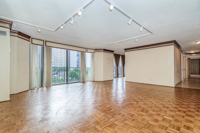 interior space with ornamental molding, a textured ceiling, light parquet flooring, and rail lighting