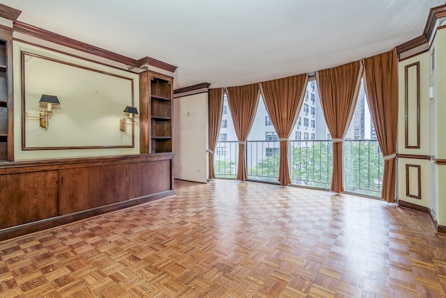 unfurnished living room with a wealth of natural light, a textured ceiling, parquet floors, and wooden walls