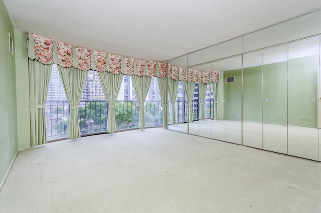 carpeted empty room featuring a textured ceiling