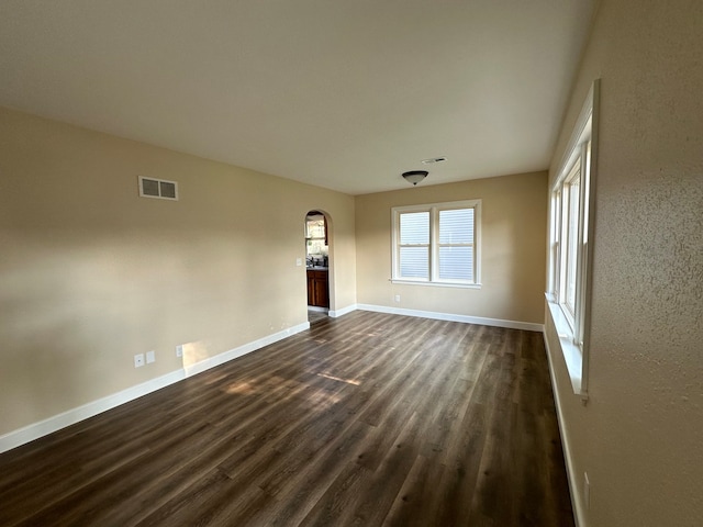 empty room with dark hardwood / wood-style flooring