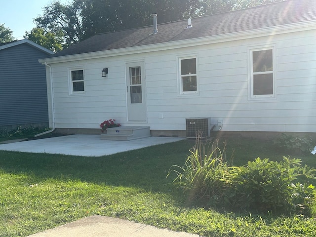 back of property featuring central air condition unit, a yard, and a patio