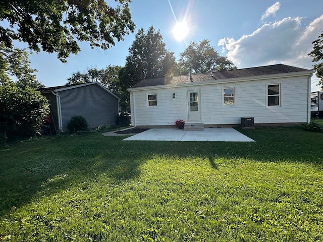 rear view of property with a patio, a yard, and central AC unit