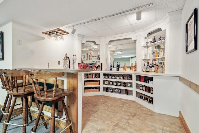 bar with track lighting and a drop ceiling