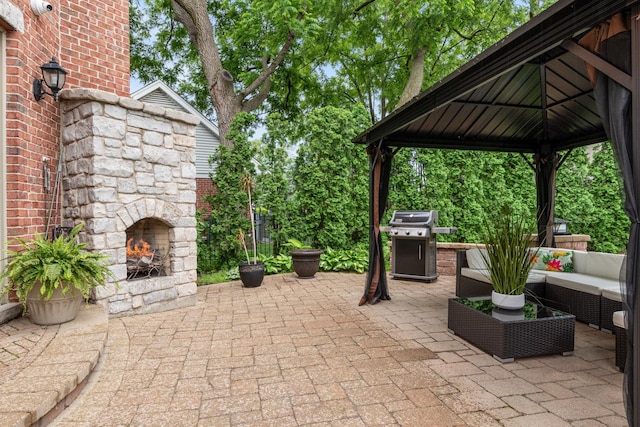 view of patio with a gazebo, area for grilling, and an outdoor living space with a fireplace