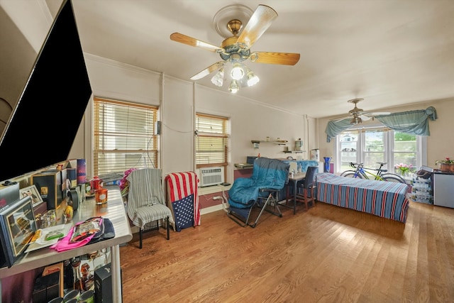 bedroom featuring light wood-type flooring, crown molding, ceiling fan, and cooling unit