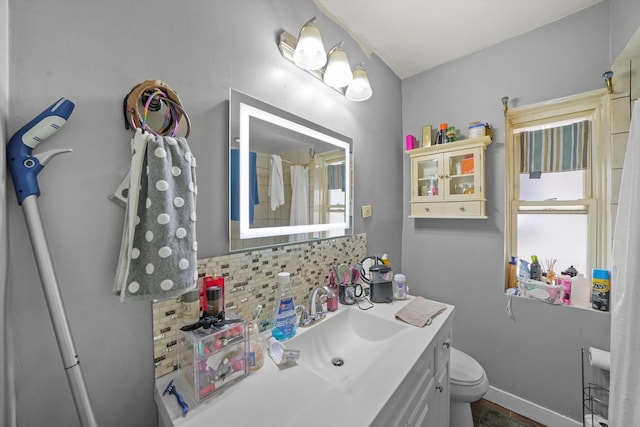 bathroom with toilet, decorative backsplash, and vanity